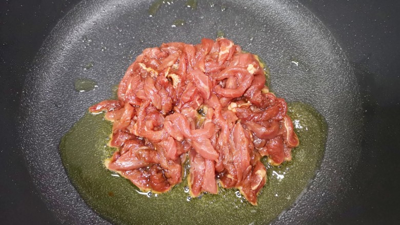 小炒牛肉,炒锅内倒适量的食用油烧热，下入腌好的牛肉。