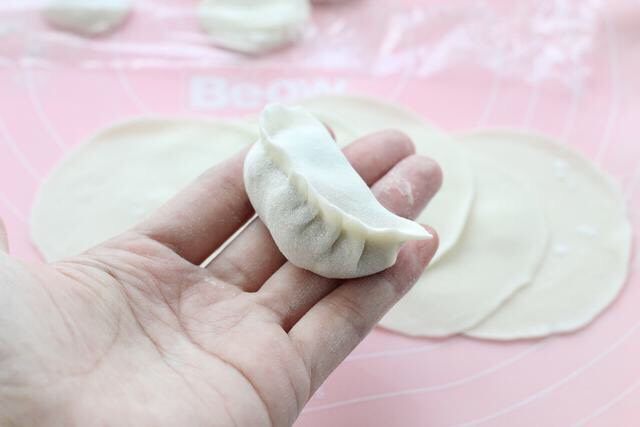 猪肉白菜水饺,取一张饺子皮在中间放适量馅料，按照自己的习惯手法包成饺子形状。
