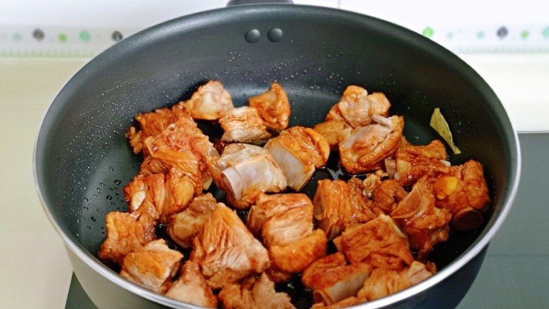 红烧土豆,再加入焯水的排骨炒色，每块排骨均匀裹上酱汁。