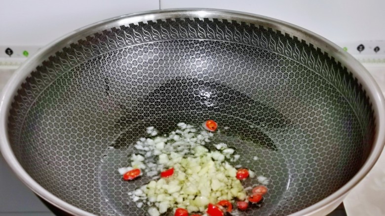 蒜蓉茄子,起油锅，加入蒜末与辣椒煸炒出香味。
