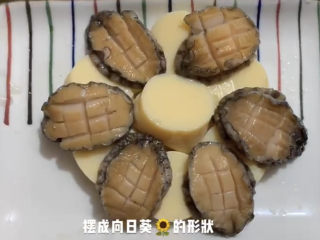 清蒸鲍鱼,日本豆腐摆在盘底，鲍鱼叠在上方。