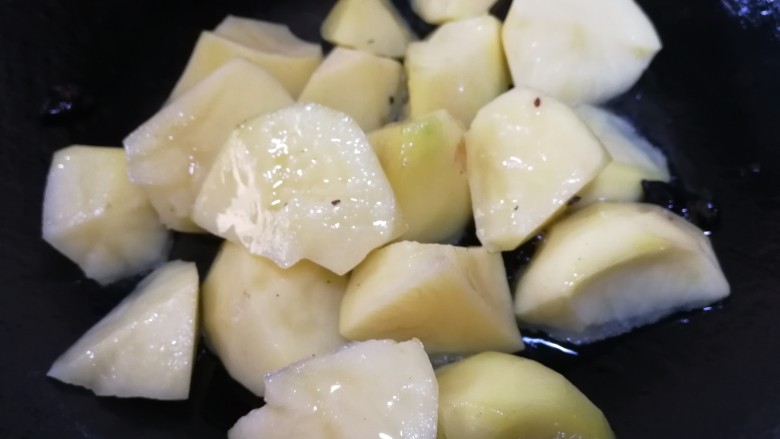 红烧土豆,放入土豆块，文火翻炒均匀，让土豆每个面都裹上油。
