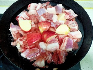 红焖羊肉 羊排,锅中放入适量清水放入羊肉和羊排放入半个苹果
