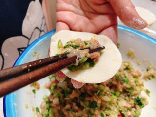 猪肉白菜水饺,取一片水饺皮，取适量肉馅放在其中。