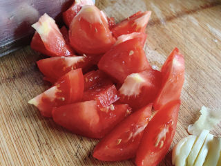 茄汁草鱼片,西红柿切块，同时蒜瓣也切片备用。