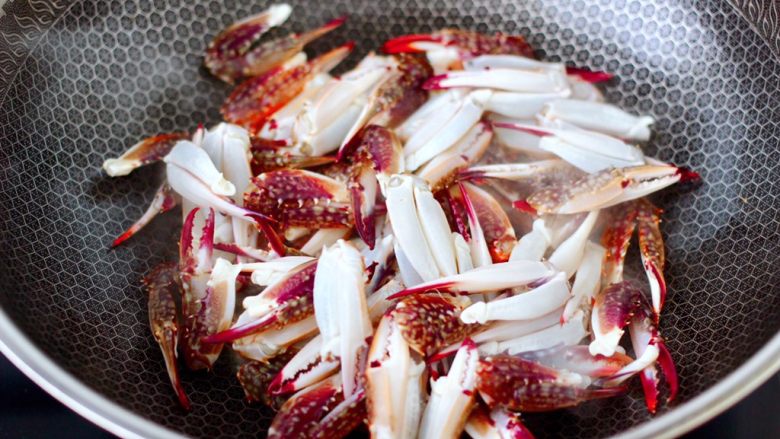 酱香麻辣蟹腿,热锅倒入比平时炒菜多一点的油烧热，放入梭子蟹腿开始慢慢炸制。