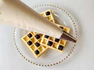 蓝莓奶油华夫饼，和孩子一起做！,裱花袋装好圆形的裱花嘴，把奶油装进裱花袋，没有圆形裱花嘴的花，直接剪一个小口也可以。