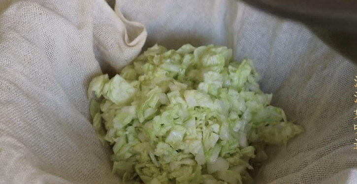 猪肉白菜水饺,差不多一个小时了，大白菜洗净出水很多了，把大包菜放入纱布中，可以方便挤掉多余的水分。