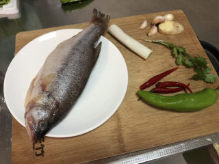 红烧鱼,食材合照：海鲈鱼一条，葱白一段，姜一小块，蒜四瓣，香菜一根，小米辣三根，青椒一根