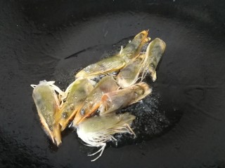 西芹炒虾仁,热锅凉油，油微热放入虾头。