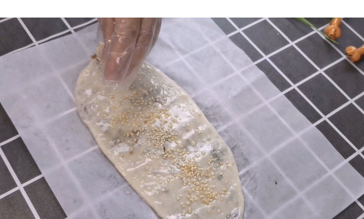 梅干菜烧饼,在做好的烧饼上抹上一层油，再均匀来一点白芝麻，是不是已经烧饼的模样出来了。提醒：一定要放在油纸上擀哟