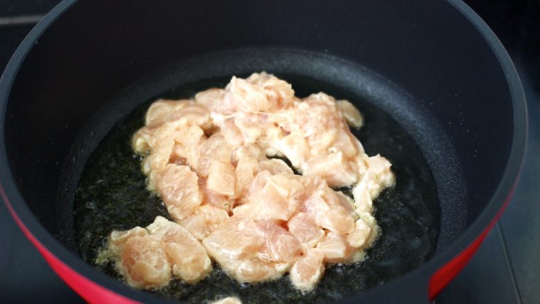 鸡丁西葫芦盖浇饭,油锅烧热后，放入腌制好的鸡丁。