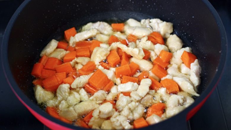 鸡丁西葫芦盖浇饭,加入胡萝卜丁，继续翻炒至胡萝卜变软。