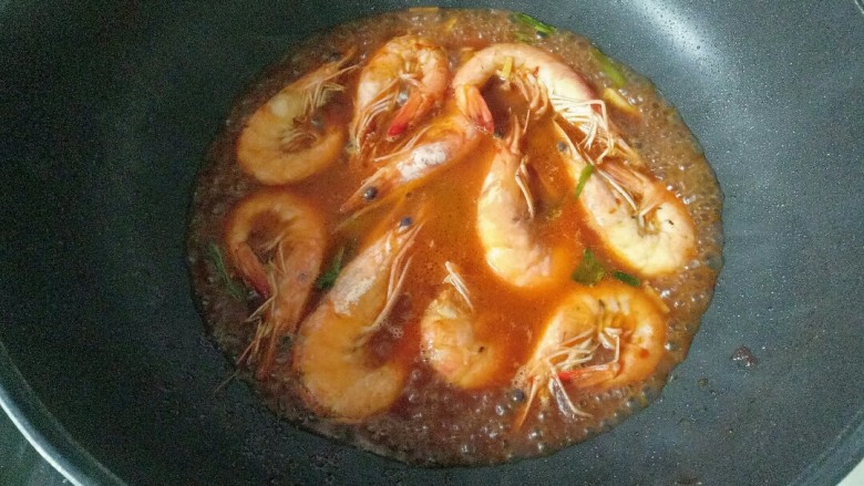 爆炒基围虾,倒入料汁，加入少许清水，大火煮开