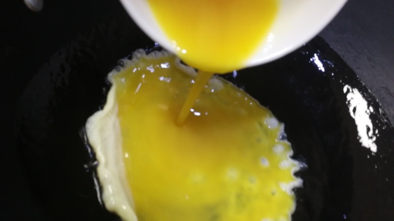 腊肠炒鸡蛋,油热倒入蛋液。