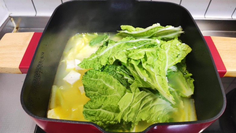 白菜豆腐汤,加入白菜叶，盖上锅盖再煮5分钟。