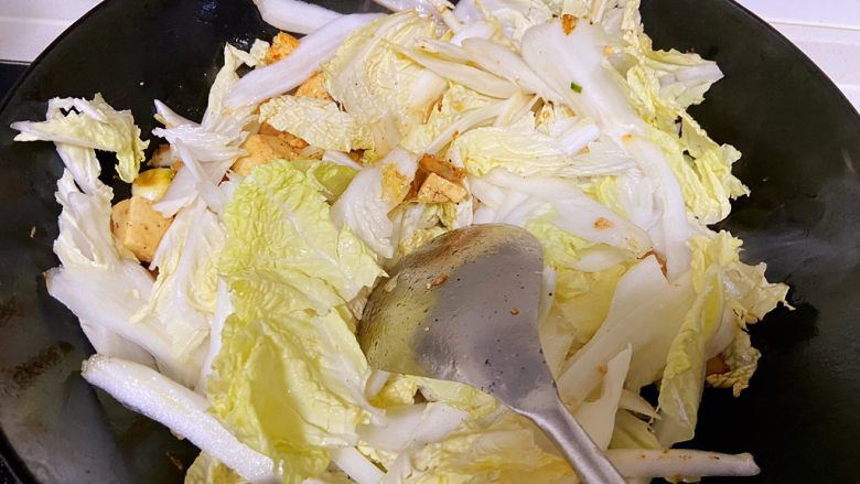 白菜豆腐汤,倒入大白菜叶翻炒。