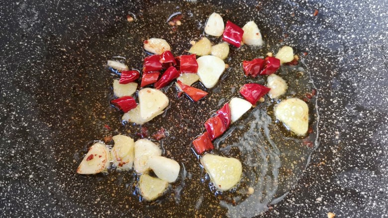 干锅包菜,锅里继续加入食用油烧热，下入生姜、蒜片和干红辣椒炒香。