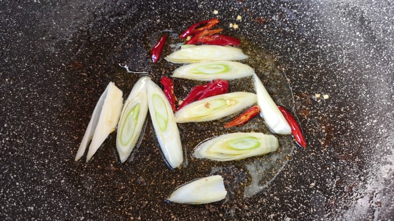 西芹炒牛肉,锅里留余油继续烧热，下入大葱和干红辣椒炒香。