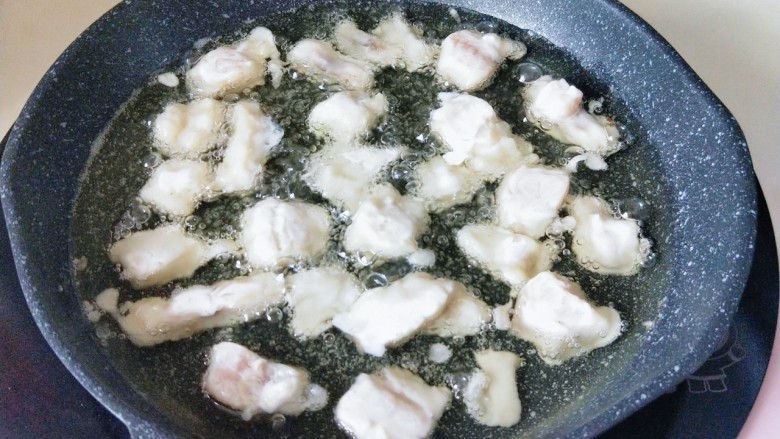 炸鱼块,将腌制好的鳕鱼块，加入面糊器具中。再用筷子将鳕鱼块均匀沾满面糊，这时油温在7成左右，将沾满面糊的鳕鱼块放入油锅中。