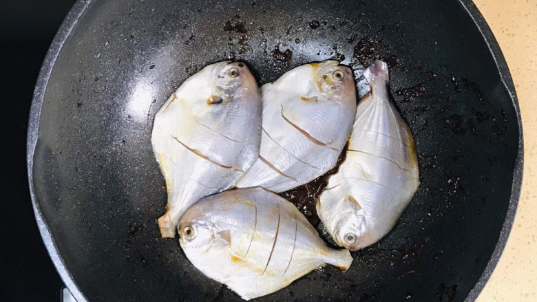 红烧鱼,继续小火，将鲳鱼码放进锅里，慢火煎至金黄色