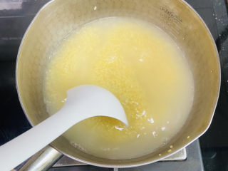 鸡蛋小米粥,期间用汤勺搅拌数次防止粘锅底