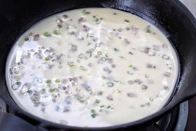 培根鸡蛋饼,在平底锅中涂抹少量的食用油，舀一勺面糊倒进去，晃动锅使面糊均匀的摊开。