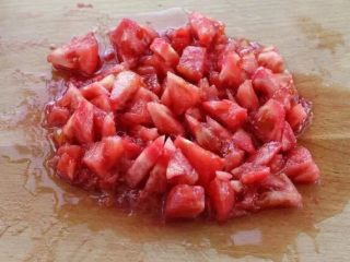 西红柿面疙瘩,西红柿表面划十字，放入开水中烫煮约20秒，剥去外皮切成丁块。