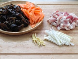白菜炒肉片,黑木耳提前泡发，洗净后撕成小片。五花肉、胡萝卜切薄片，姜和大葱切丝备用。