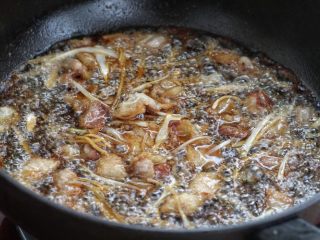 白菜炒肉片,接着放入葱、姜丝小火炒香，再调入生抽和料酒炒至五花肉上色。