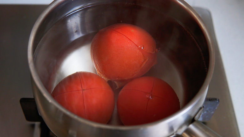 西红柿鸡蛋拌面,水煮开，番茄入锅焯烫半分钟，捞出，