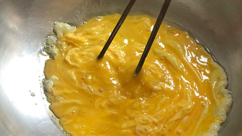 西红柿鸡蛋拌面,将鸡蛋液倒入锅中，用筷子快速搅拌，使蛋液结成小块絮状，盛出备用