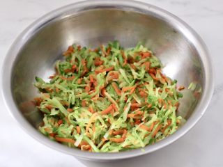 萝卜豆腐丸子,焯熟的萝卜和胡萝卜丝纳干水分放入盆中。