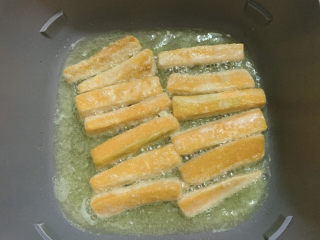 蛋黄南瓜,慢火炸制每一面都金黄，同时用筷子尝试能否一下子戳入南瓜，如果可行，即位成熟。