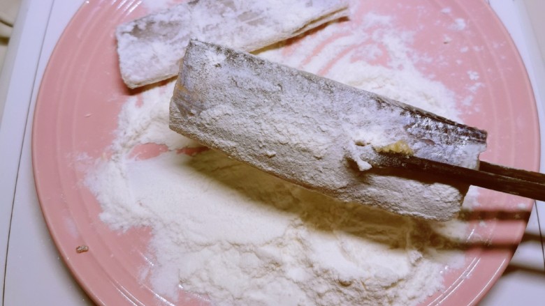 炸鱼块,腌好后去掉辅料，放入面粉中，包裹上薄薄一层面粉。