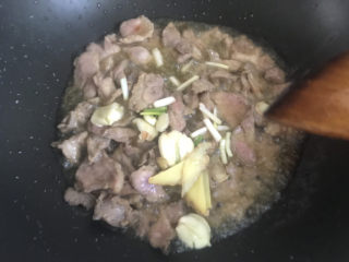 白菜炒肉片,炒至变色后加入葱姜蒜爆香