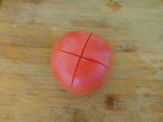 西红柿面疙瘩,首先将西红柿清洗干净，顶部切十字花刀