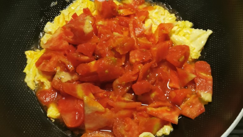 西红柿鸡蛋拌面,放入番茄块，翻炒。