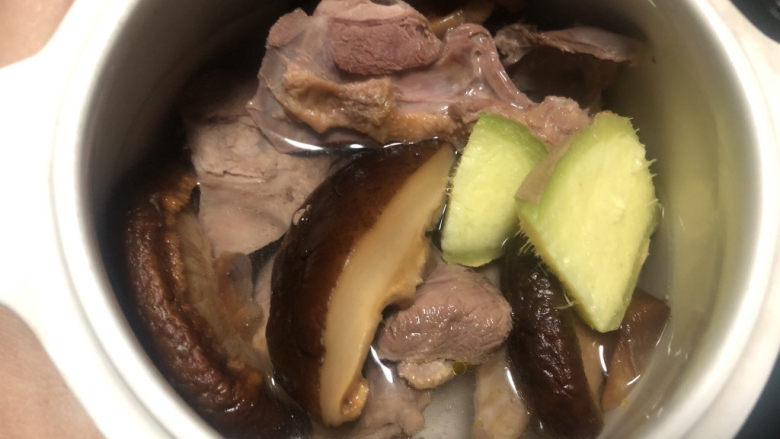 花胶鸽子金汤,炖盅里放入鸽肉，香菇和姜片，倒入矿泉水，喜欢喝汤的可以多倒点水。