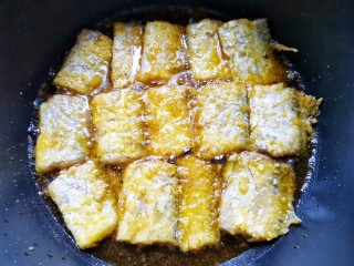 炸鱼块,锅里入油，放入带鱼小火煎至两面金黄酥脆盛出。