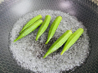 培根秋葵卷,锅中加入清水大火烧开加入适量盐和食用油，放入清洗干净的秋葵。焯熟捞出过凉水