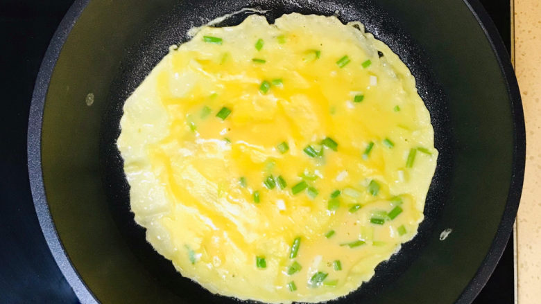 培根鸡蛋饼,拿起锅，左右摇晃起来，使面糊均匀地摊于锅里