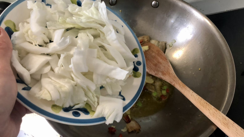 白菜炒肉片,转中火，下白菜片，翻炒一两分钟，白菜叶开始出水