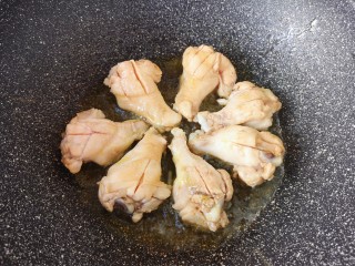 可乐鸡翅根,炒锅内倒入食用油烧热，放入鸡翅根。