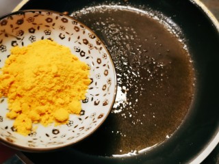 蛋黄南瓜,锅中留下一汤匙食用油，放入蛋黄粉。