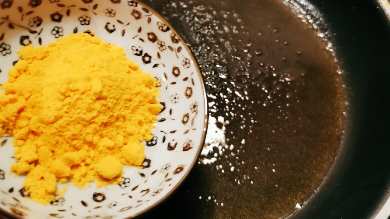 蛋黄南瓜,锅中留下一汤匙食用油，放入蛋黄粉。