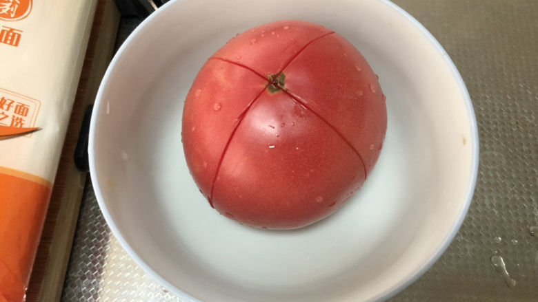 西红柿鸡蛋拌面,番茄清洗表面划十字花刀