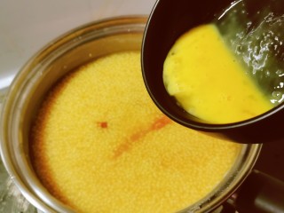 鸡蛋小米粥,将鸡蛋液倒入小米粥里。