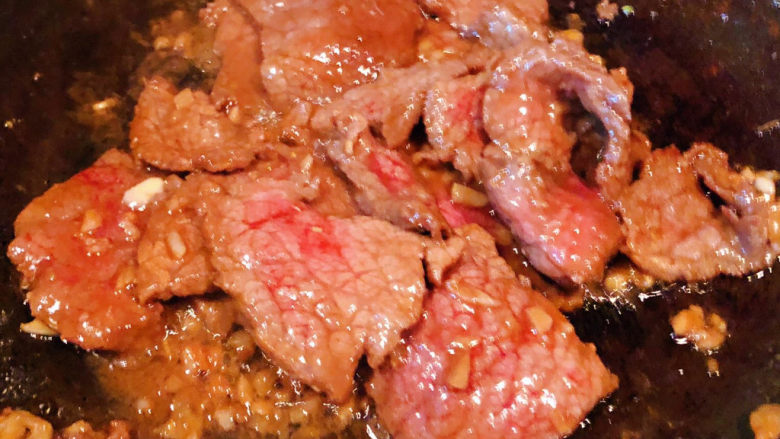 小炒黄牛肉,锅中倒入底油加热放入蒜粒爆香再放入小黄牛肉炒至断生变色