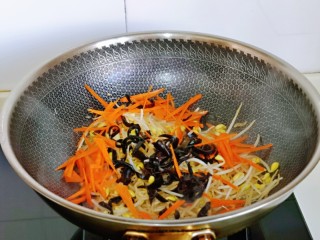 爆炒绿豆芽,再加入切好的胡萝卜丝与黑木耳丝，加入半小碗纯净水。